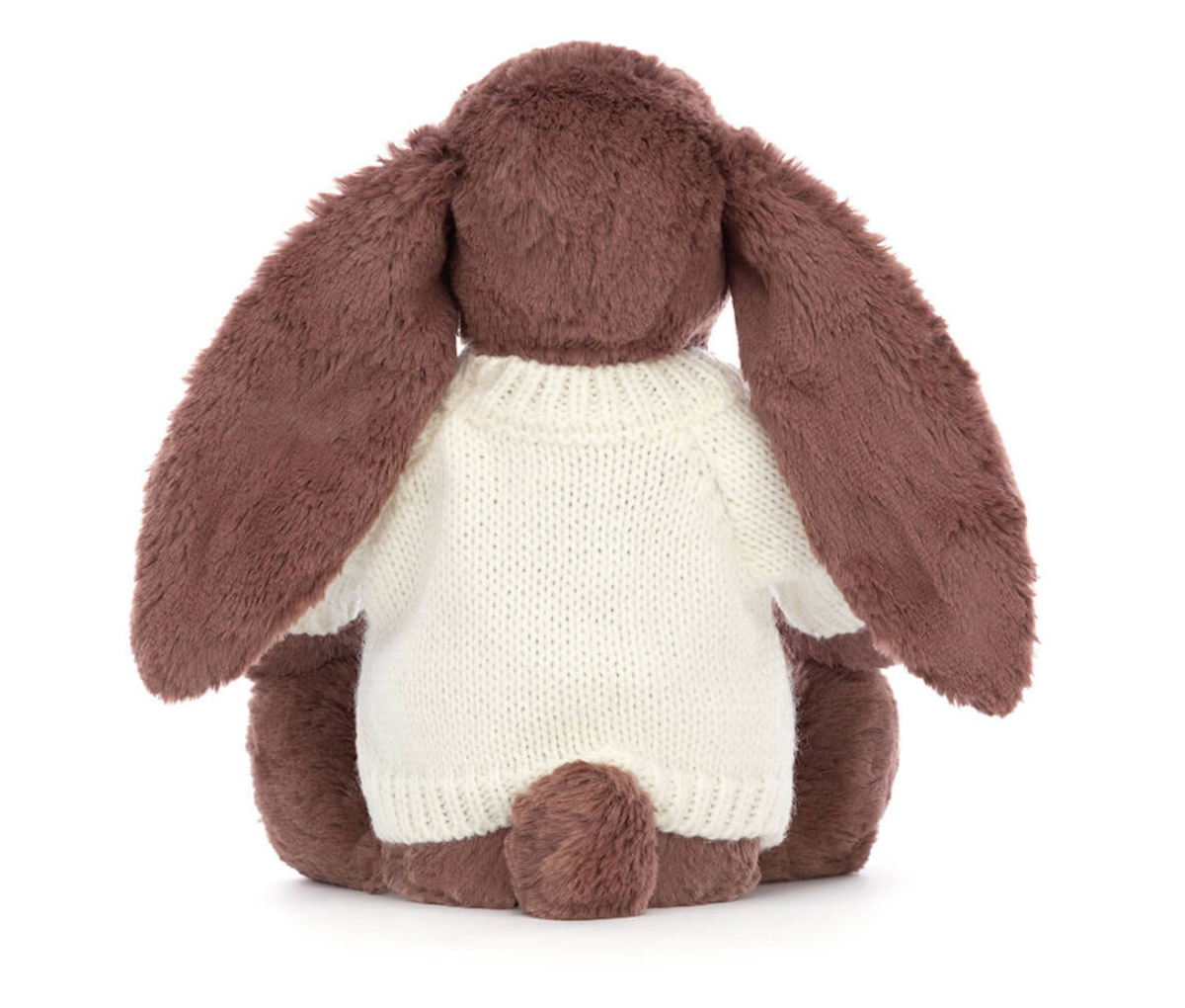 A brown bunny plush toy with long ears, wearing a white knitted jumper