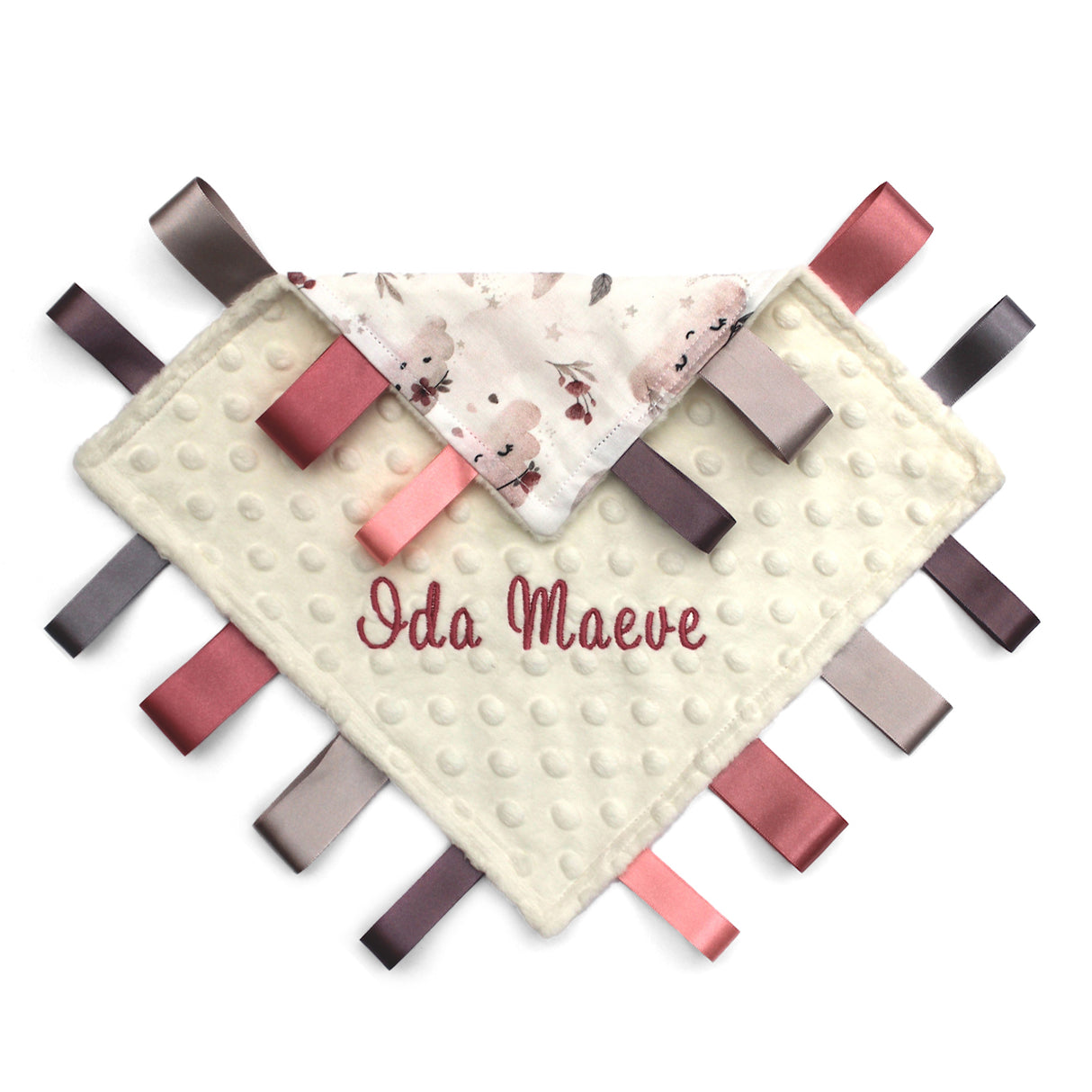 Handmade baby taggy comforter with a floral pattern on a white background, backed with plush fabric, and secured with ribbon tags and personalised name.