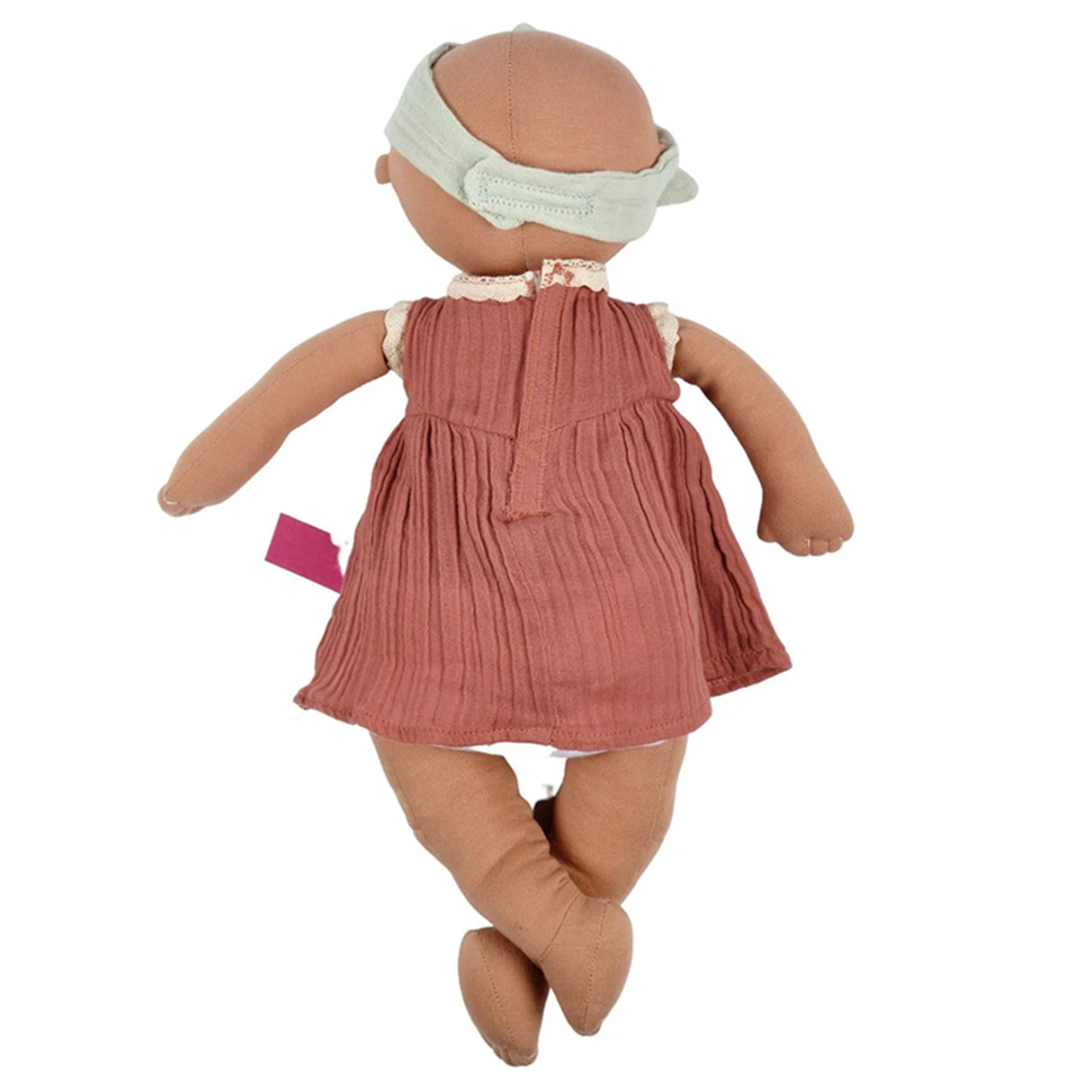 Baby doll with a pink dress and headband on a white background