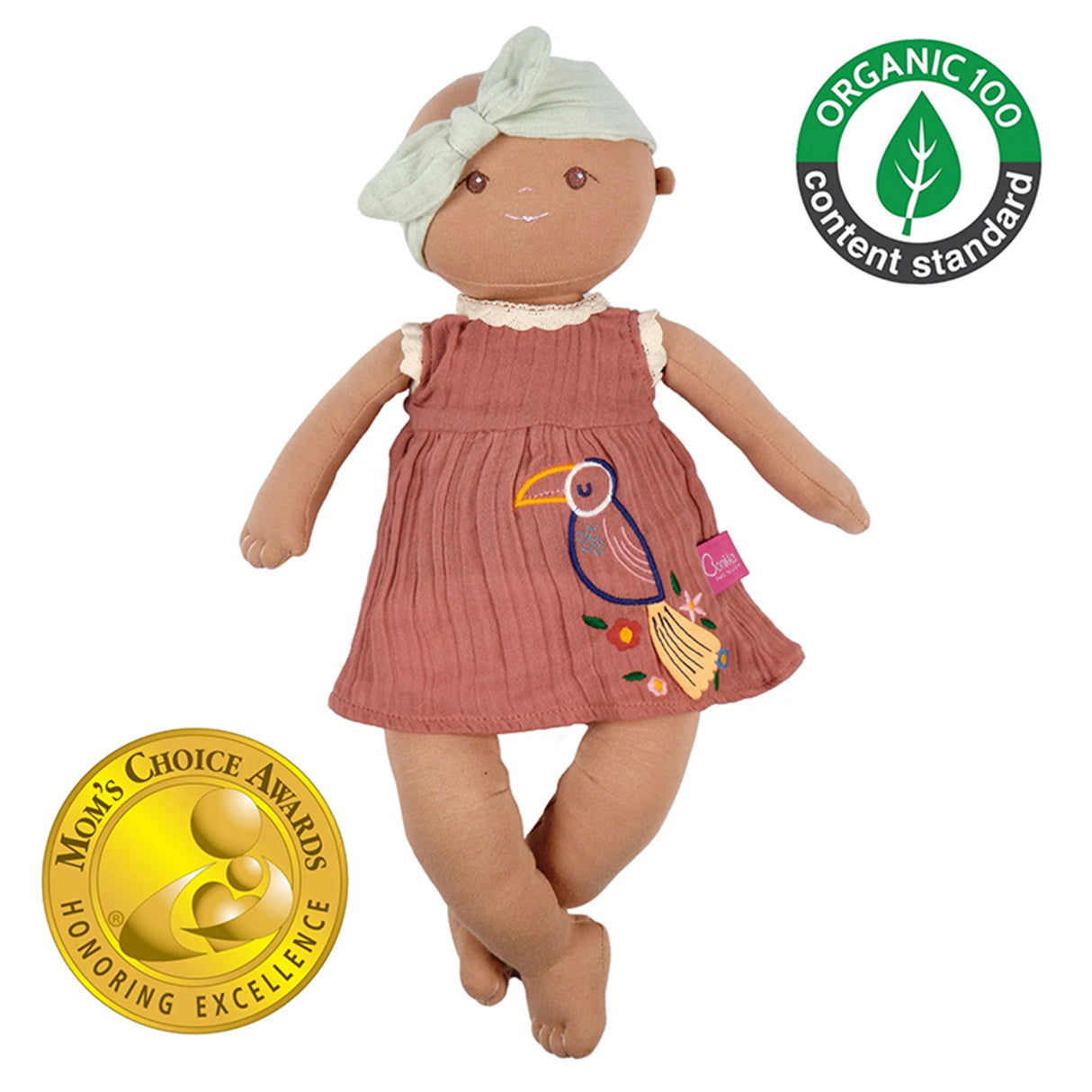 Doll wearing a pink dress with a bird design, surrounded by organic content and Mom's Choice Award logos on a white background.