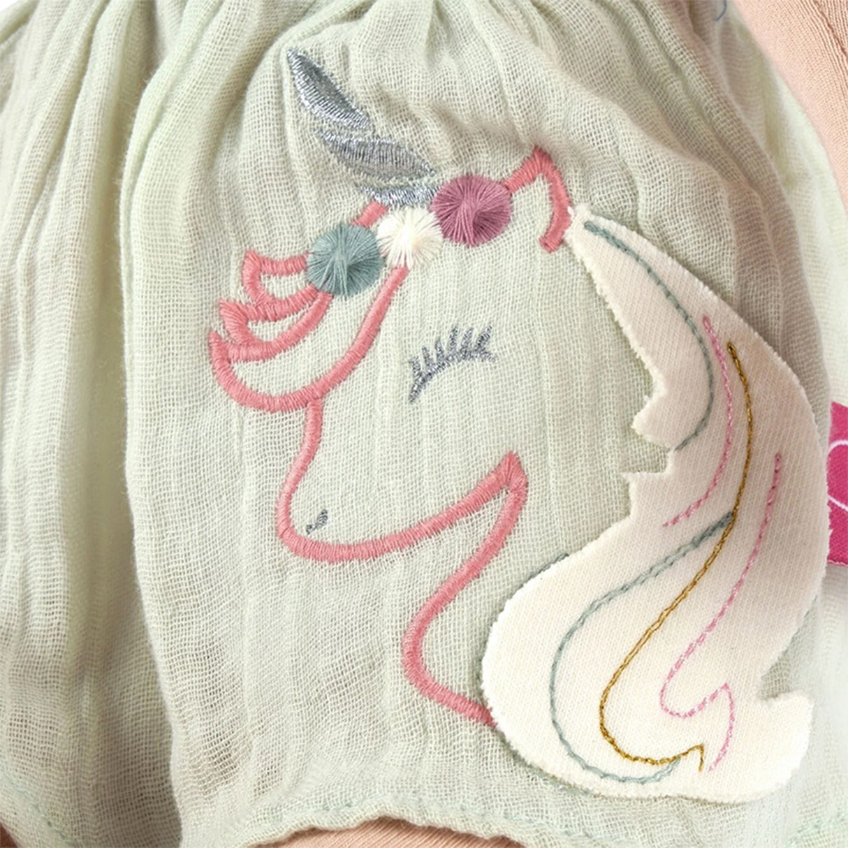 Embroidered unicorn design on a soft fabric background