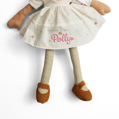 Plush soft rag doll with name Polly personalised on the cream dress which has brown and yellow flowers. The doll also has brown and cream stripey tights and brown shoes on a white background