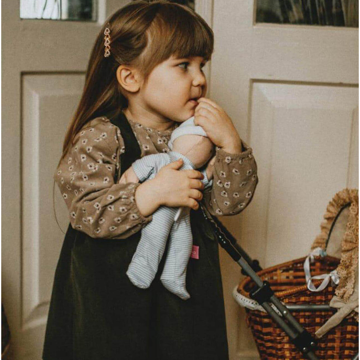 Child holding a baby bouncer with a neutral background