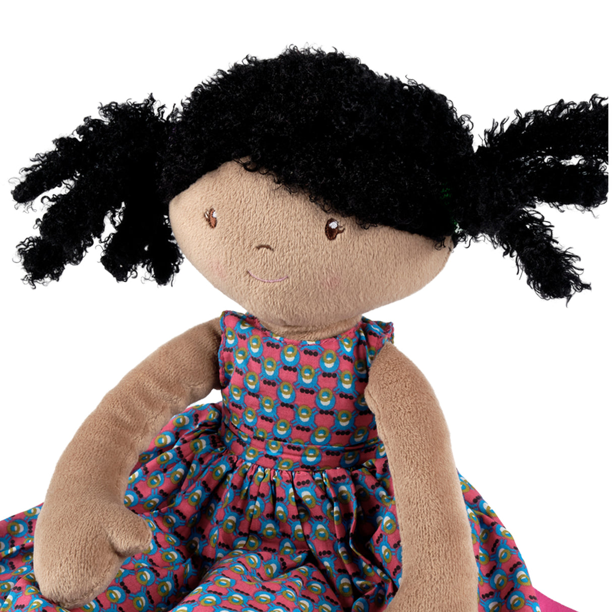 Plush doll with black hair styled in pigtails, wearing a colourful dress on a white background