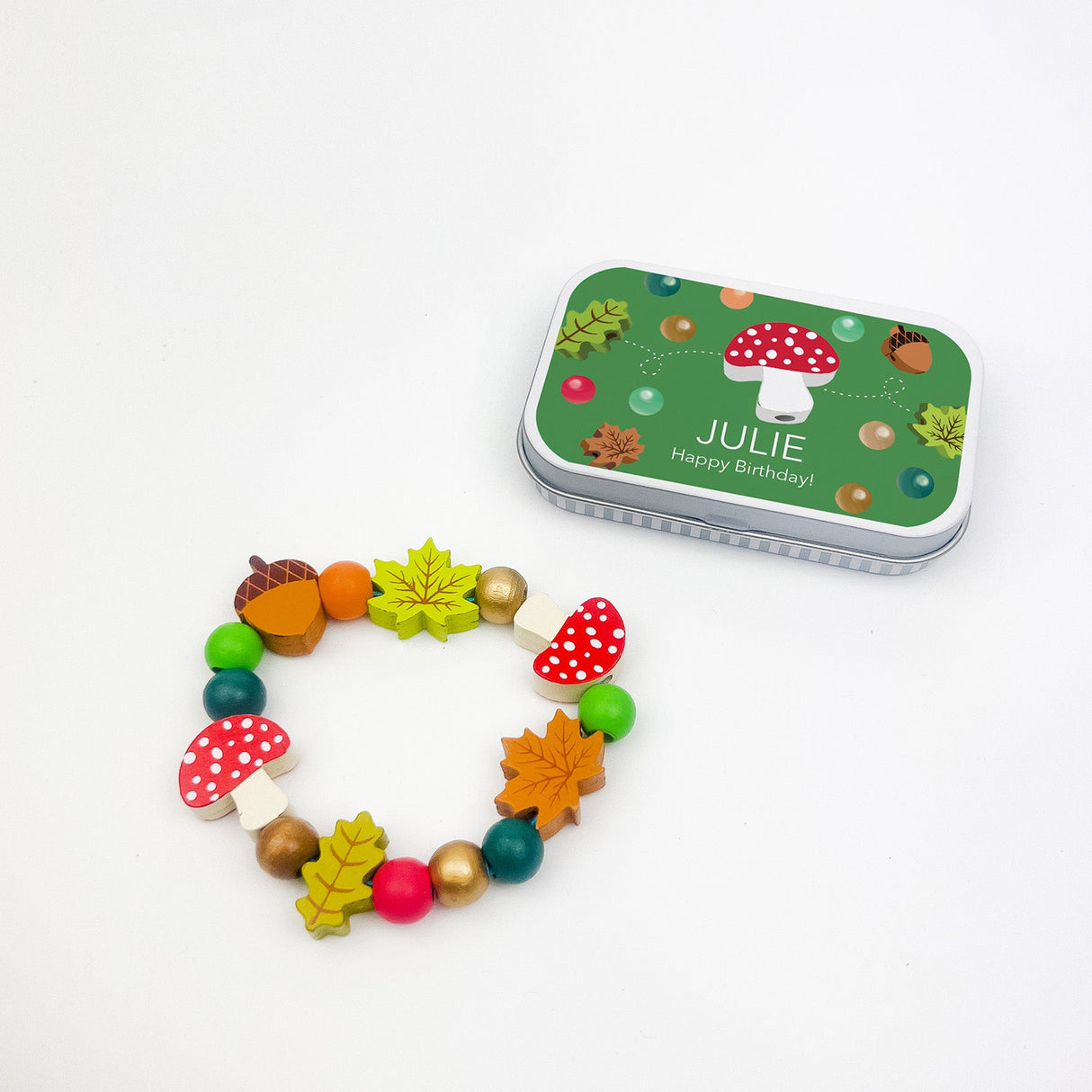 Colorful children's bracelet with a matching tin box on a white background