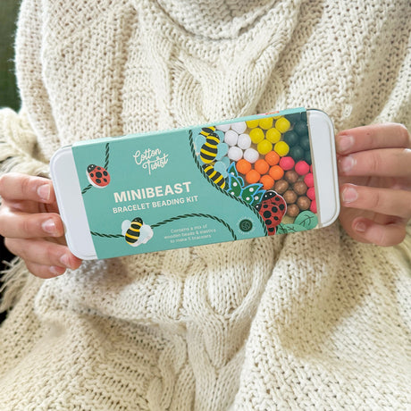 Cotton Twist Minibeast bracelet beading kit held by a person wearing a beige sweater.