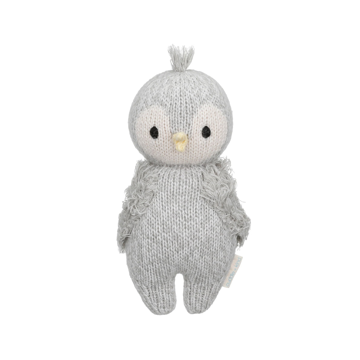 Handknitted baby penguin soft toy on a white background