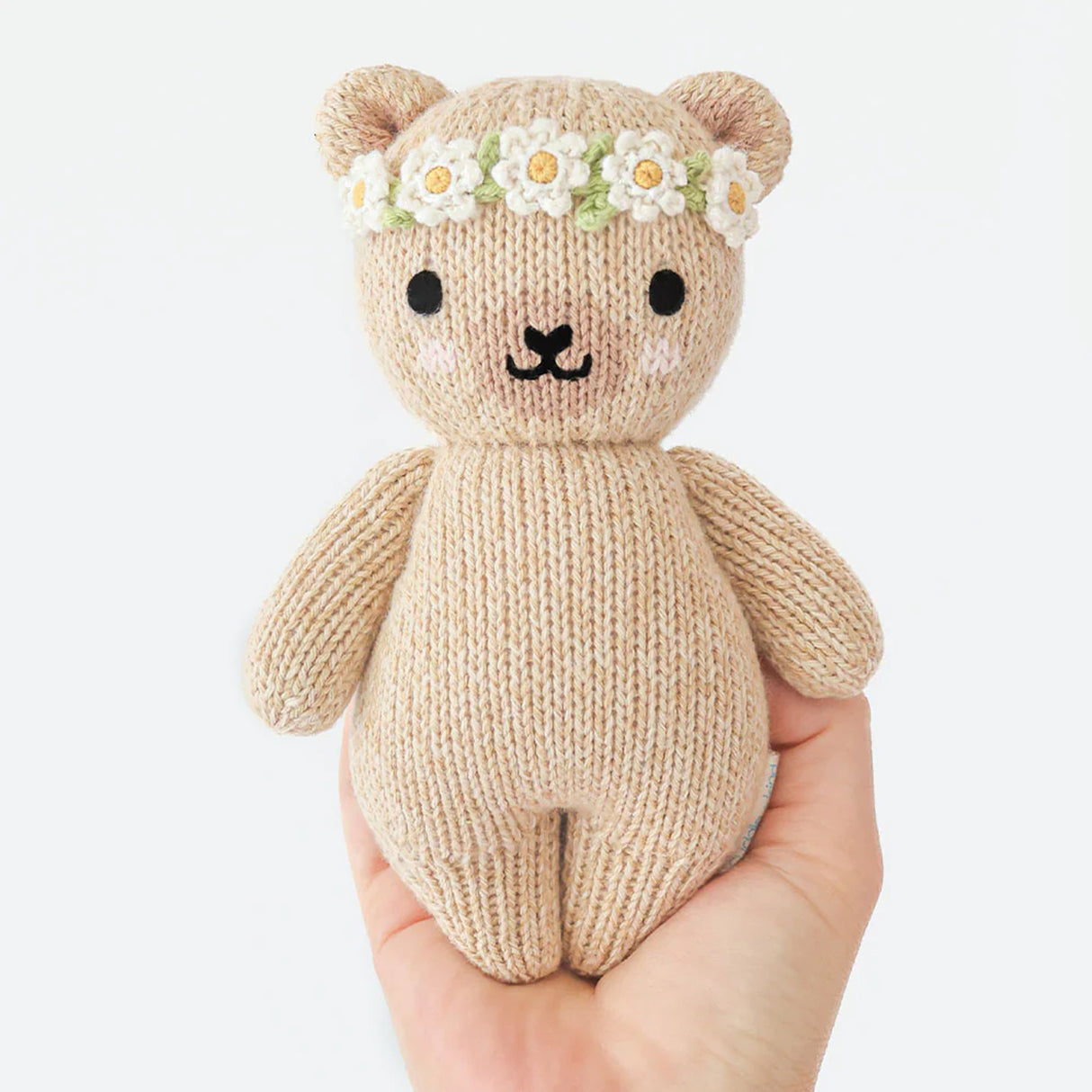 Cuddle+kind Handmade knitted teddy bear with a flower crown held in a hand