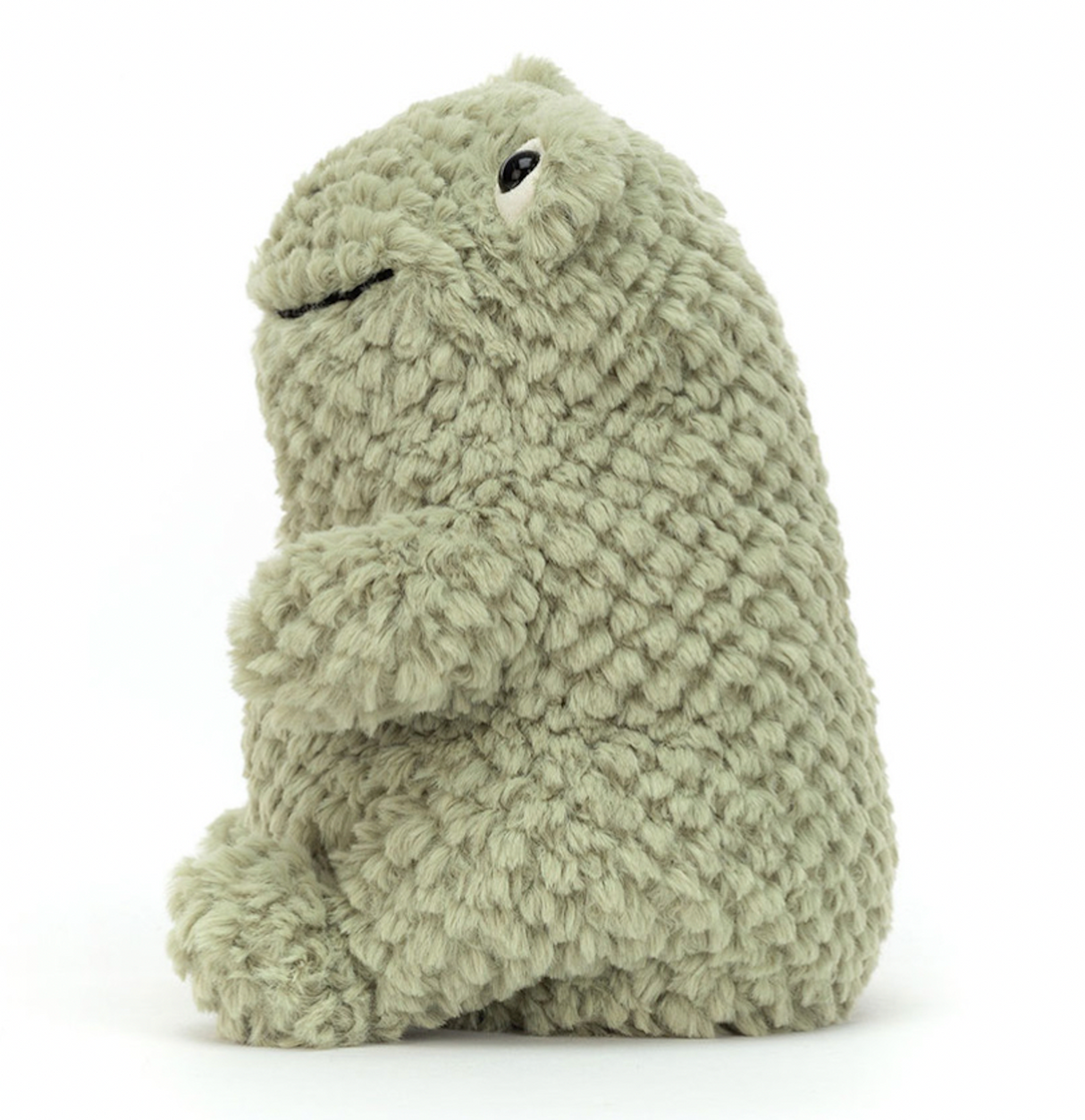 A plush toy resembling a green frog with a happy facial expression, made from a soft, textured fabric.