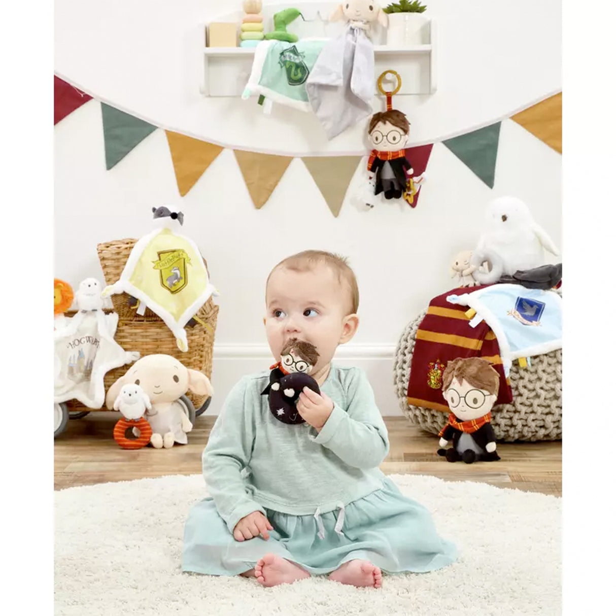 Baby holding a plush toy in a room with Harry Potter-themed decorations