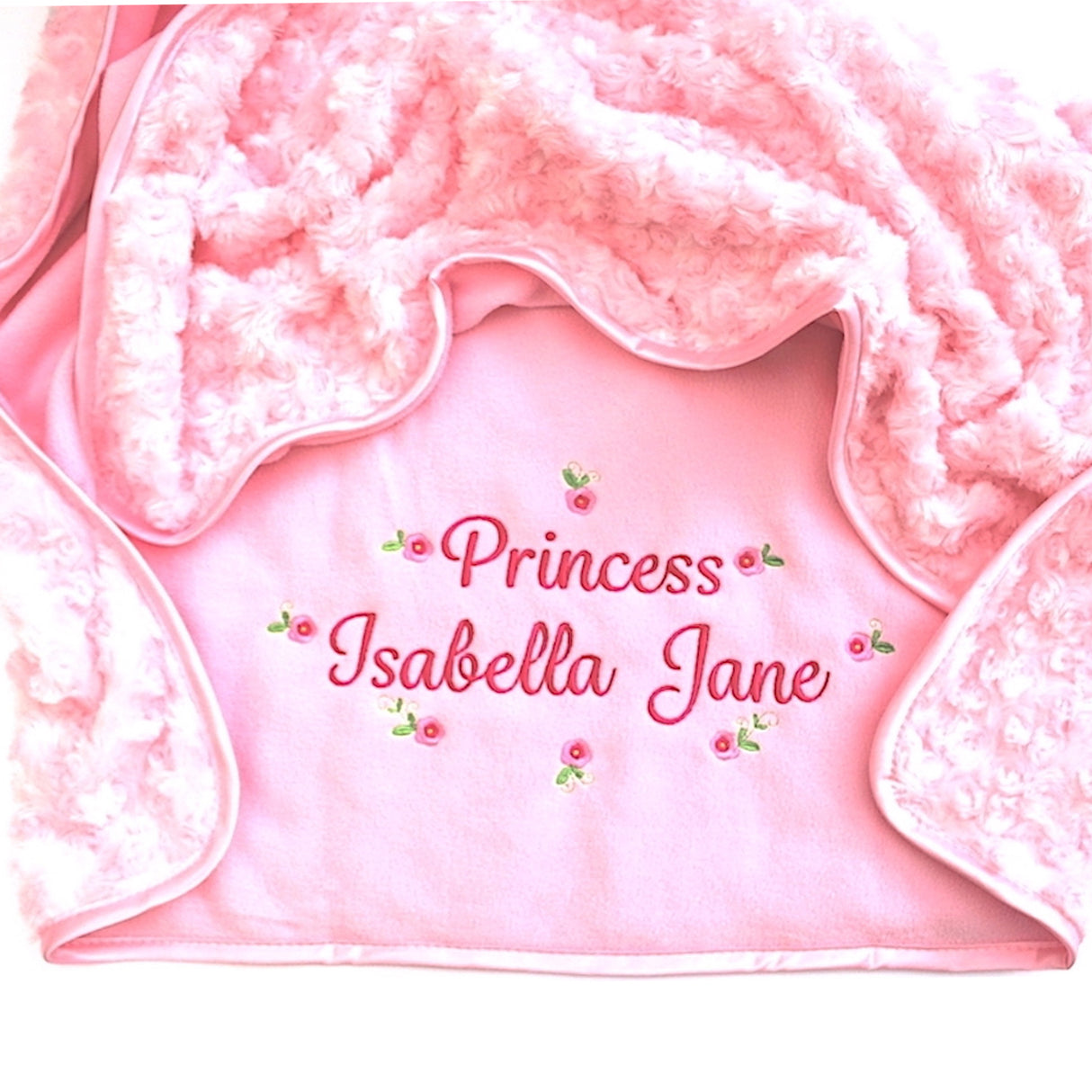 Pink blanket with personalised embroidery name with flowers on a white background