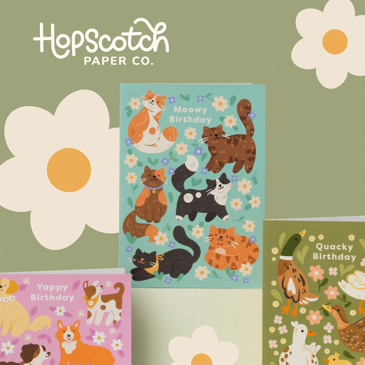 Birthday Card with turquoise background 6 different colourd brown black cats and flowers on a green background with two other birthday cards