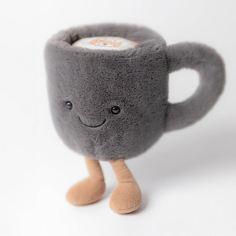 A plush coffee cup toy with a gray exterior, corduroy boots, and a smiling face.