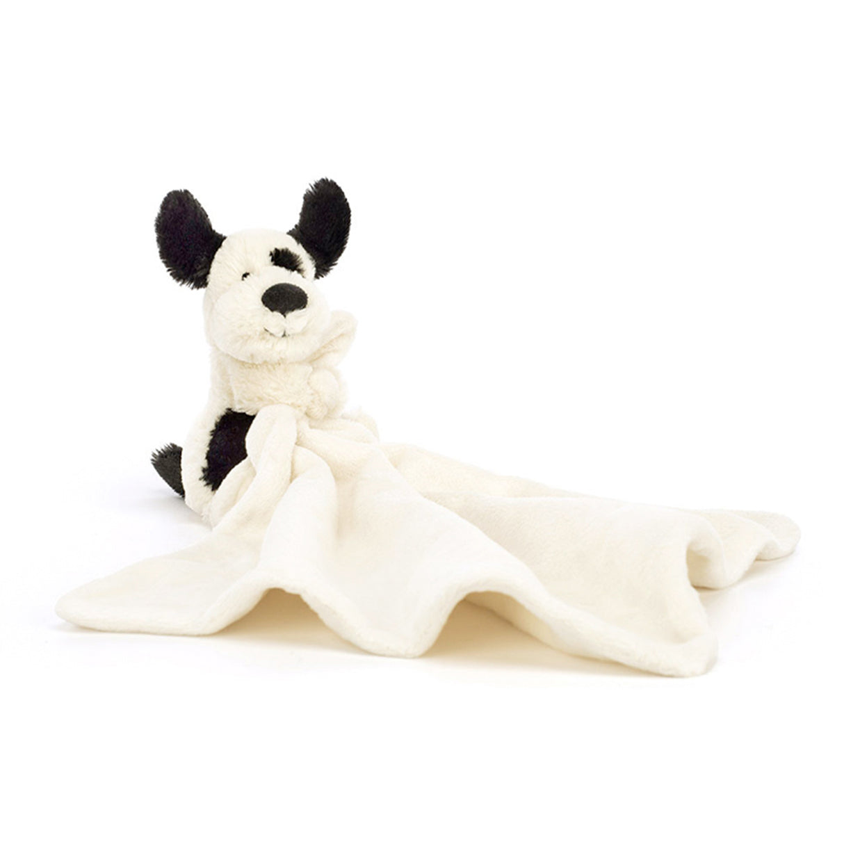 Black and white dog plush toy with a white blanket on a white background
