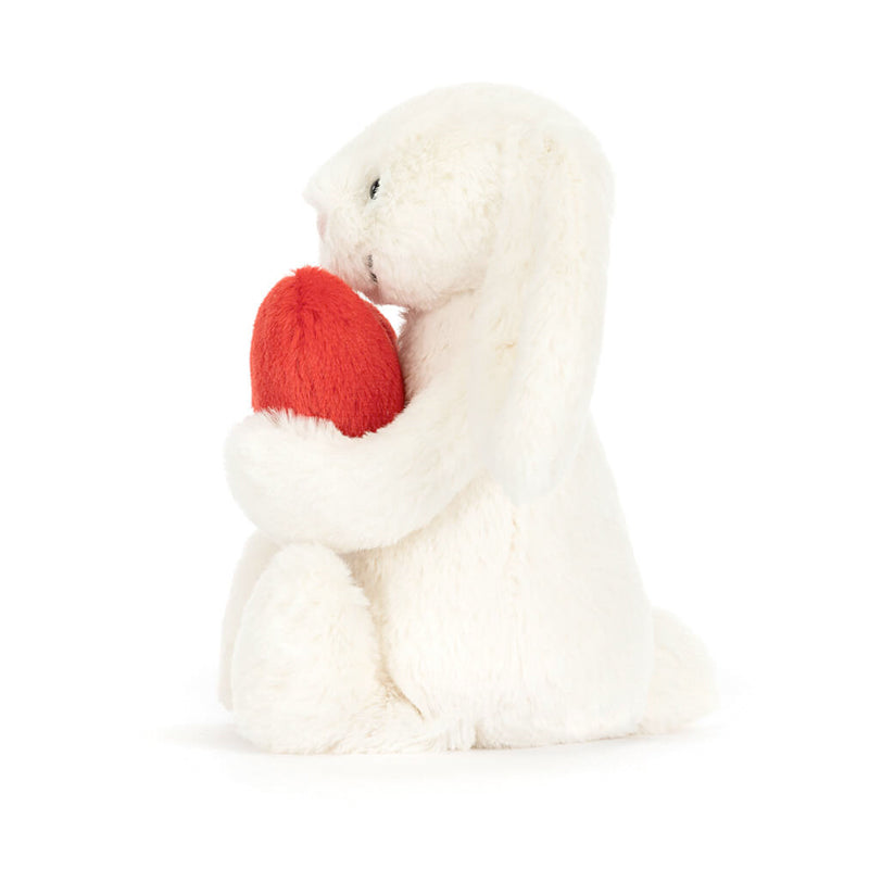 A plush toy of a white bunny holding a red love heart.