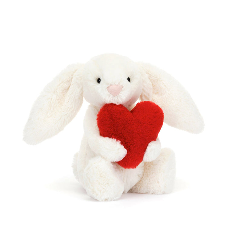 A plush toy of a white bunny holding a red love heart.