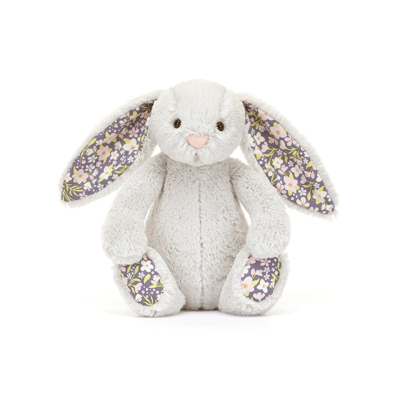 A small plush toy resembling a gray bunny with floral patterns on its ears and feet, and a white backdrop.