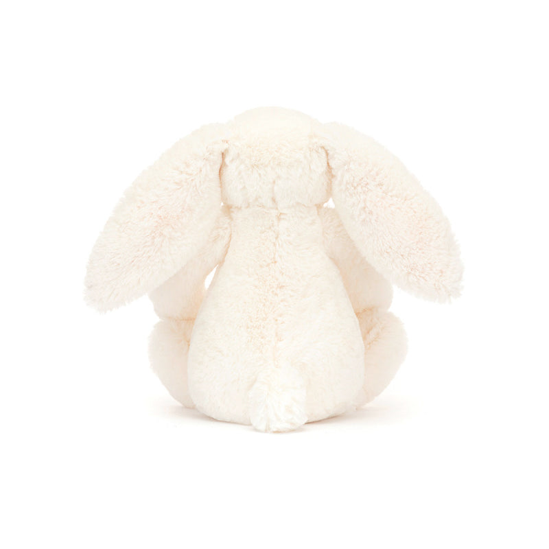 A small plush toy resembling a cream-colored bunny with soft cotton ears and feet, featuring a strawberry and cream flower pattern