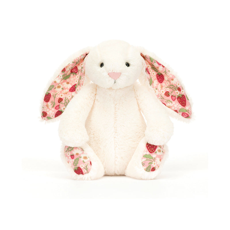 A small plush toy resembling a cream-colored bunny with soft cotton ears and feet, featuring a strawberry and cream flower pattern on a white backdrop.