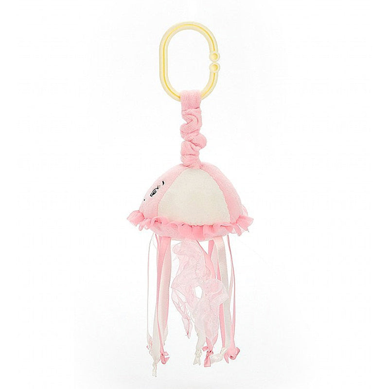 A pink Jellycat sea streamer jellyfish jitter with a smiling face and frilled tentacles, complete with a yellow ring for attachment.
