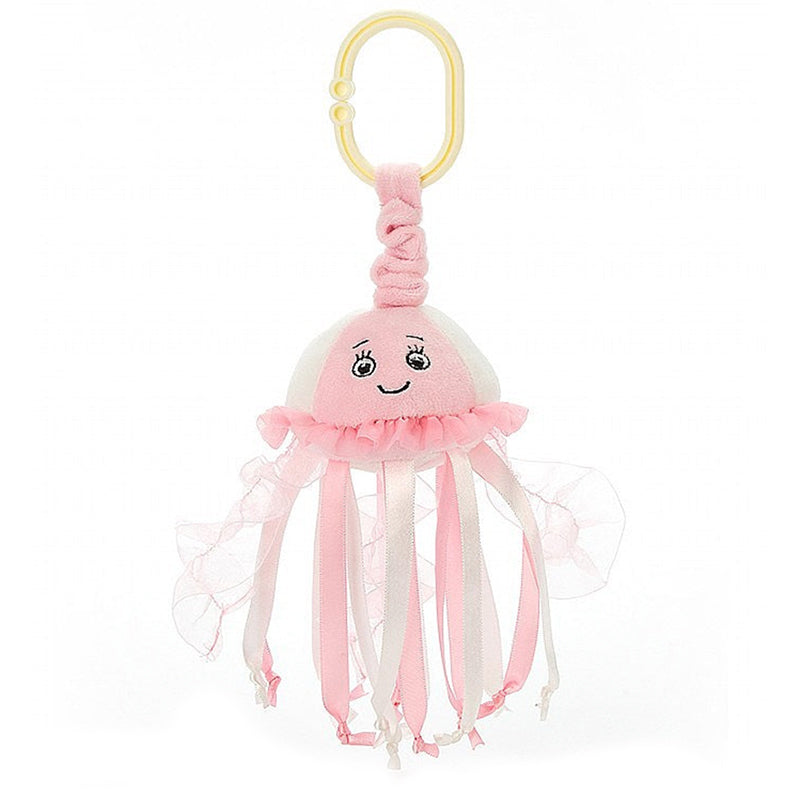 A pink Jellycat sea streamer jellyfish jitter with a smiling face and frilled tentacles, complete with a yellow ring for attachment.