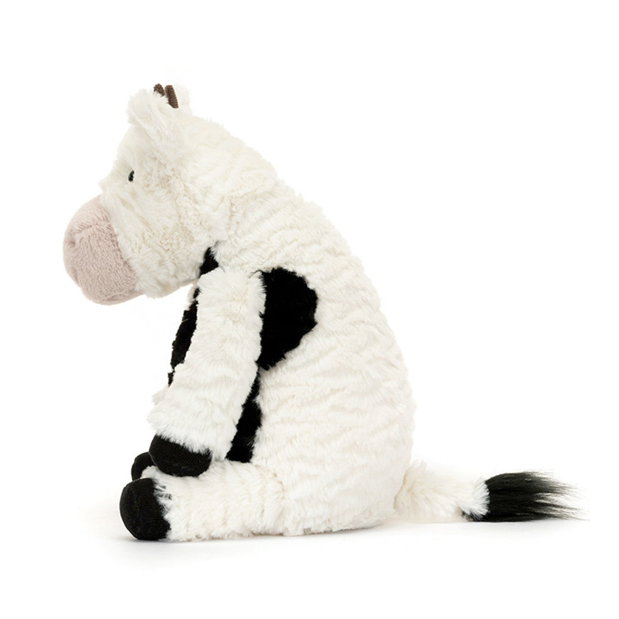 Plush toy dairy cow with black and white pattern on a white background