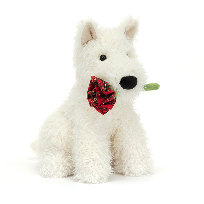 A plush toy depicting a white-coloured dog with a black suedette nose, holding a red tartan rose in its mouth.