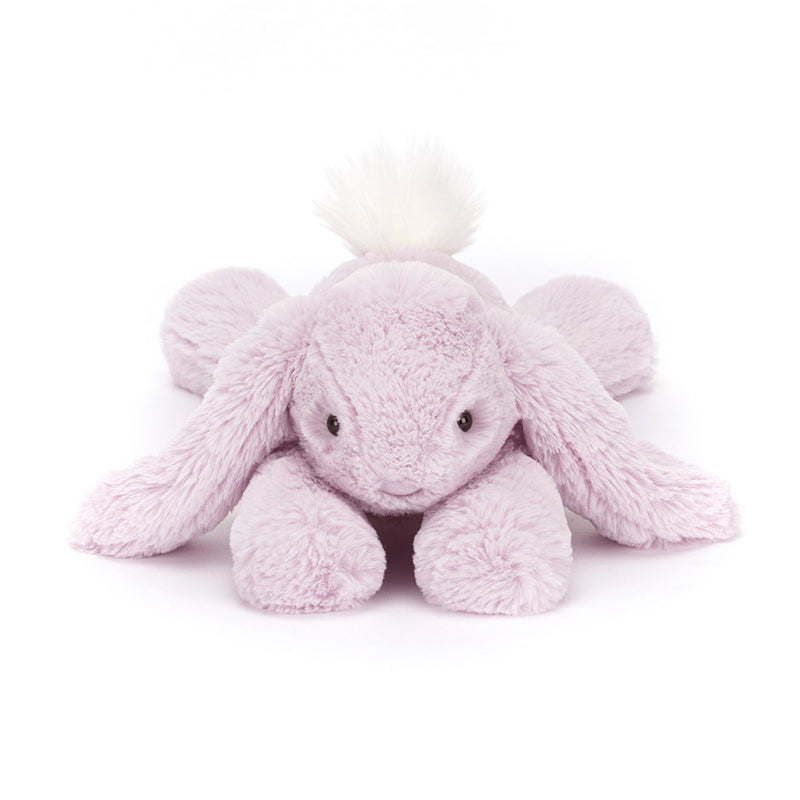A plush lavender-colored Jellycat Bashful Beige Bunny with a fluffy cream bobtail, lying down.