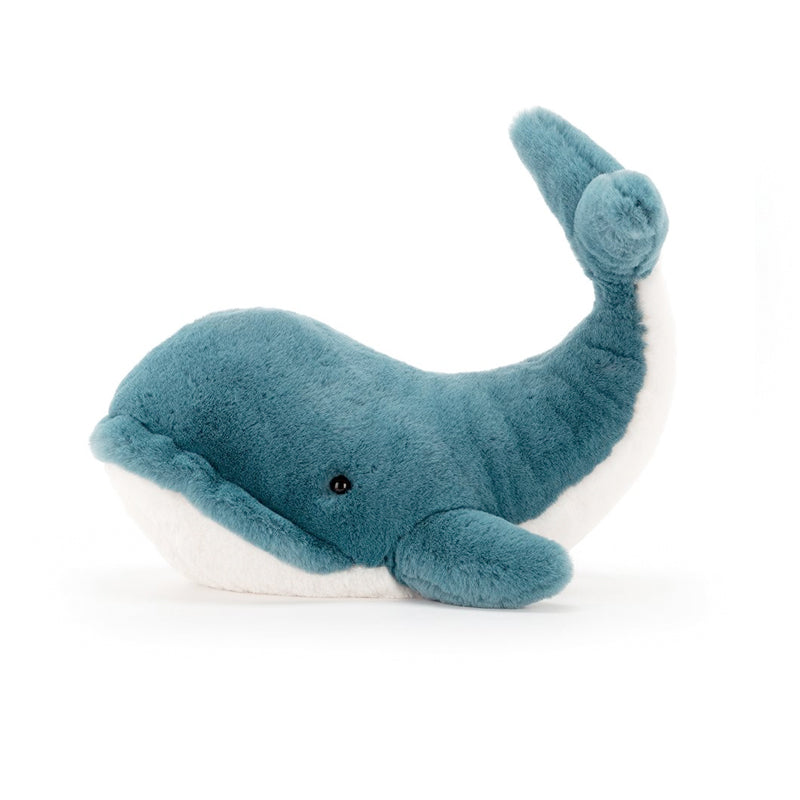A plush toy resembling a whale with vibrant teal fur and a white underbelly,