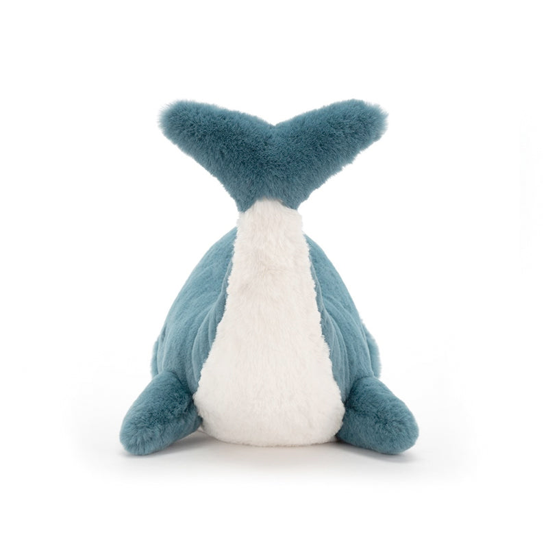 A plush toy resembling a whale with vibrant teal fur and a white underbelly, back