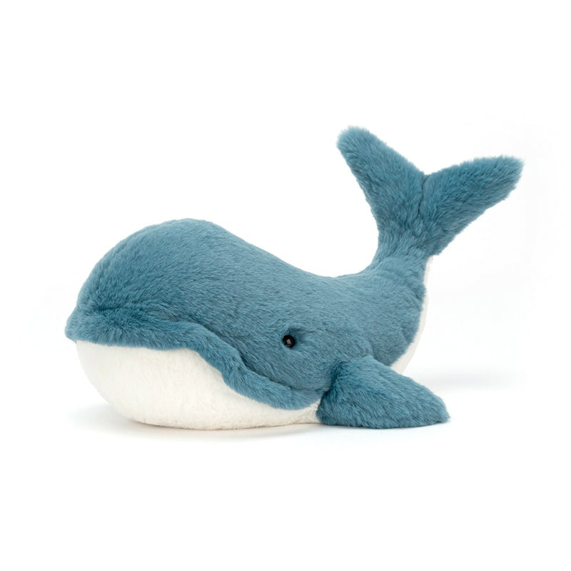 A plush toy resembling a whale with vibrant teal fur and a white underbelly,