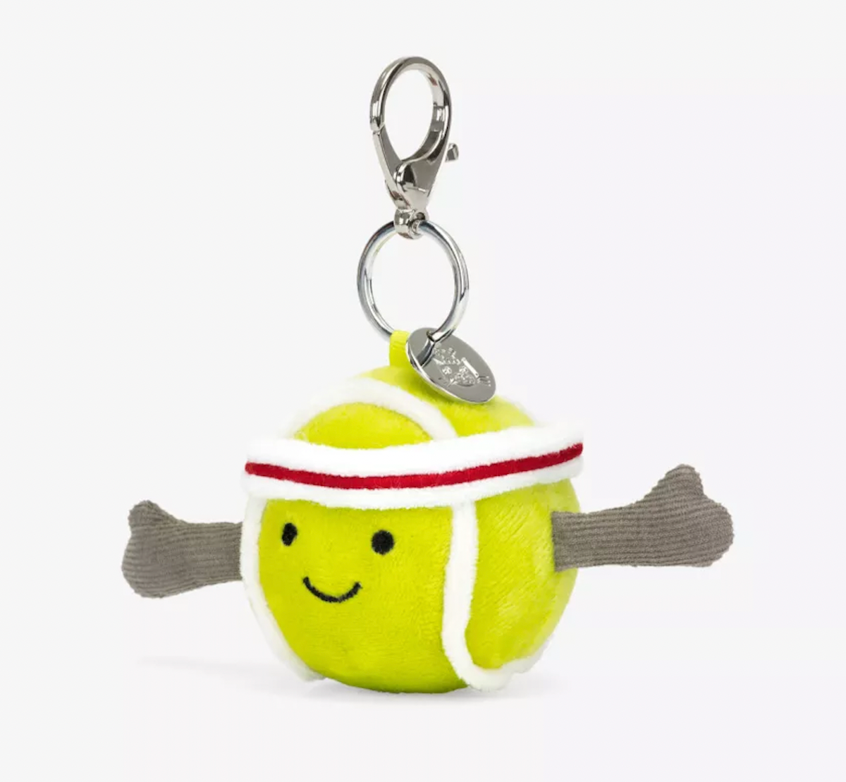 A plush toy in the shape of a yellow tennis ball with red and white details, wearing a white and red headband, attached to a silver clip and chain.