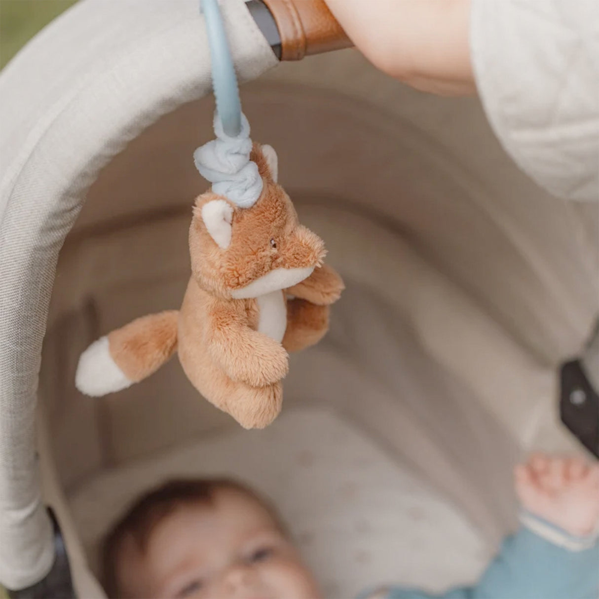 Little Dutch Pull and shake Plush fox toy hanging from a crib rail with a baby looking up at it.