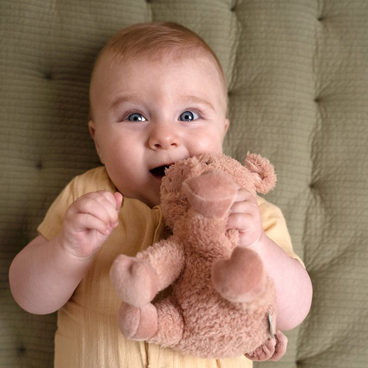 Baby holding pig soft toy