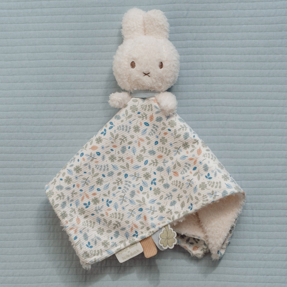 Miffy bunny toy with a floral cloth blanket