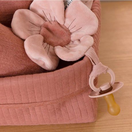 A soft pink dummy cloth shaped like a flower with an attachment, suitable for babies.