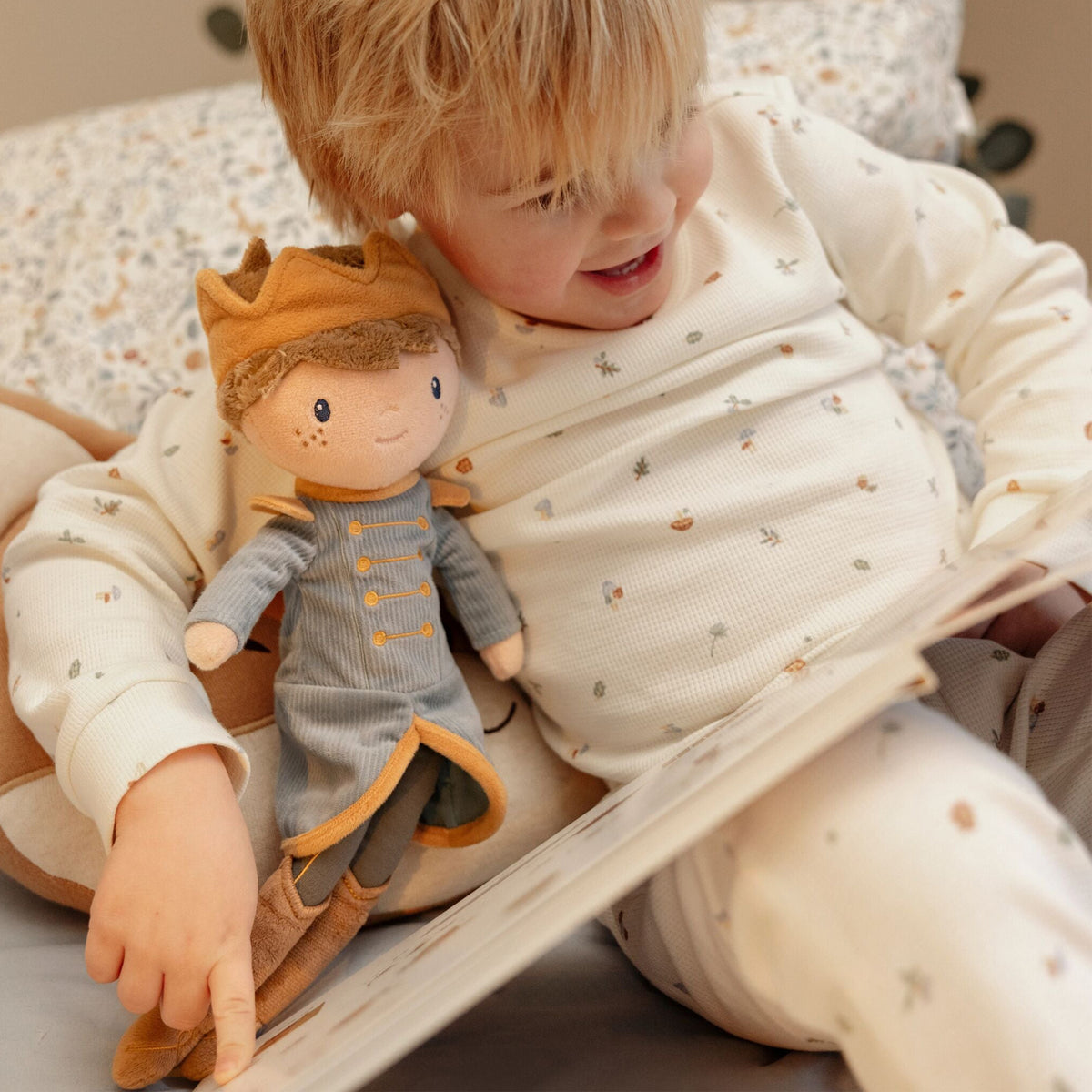 Child holding Little Dutch Prince Jim Doll - 35cm soft cuddle doll in teal prince outfit