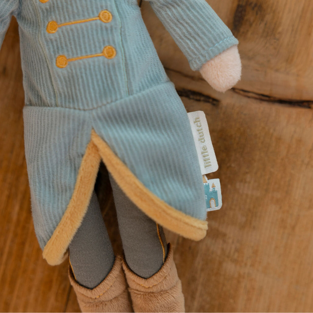 Close-up of Little Dutch Prince Jim Doll showing ribbed teal coat, gold trim, grey trousers and Little Dutch label