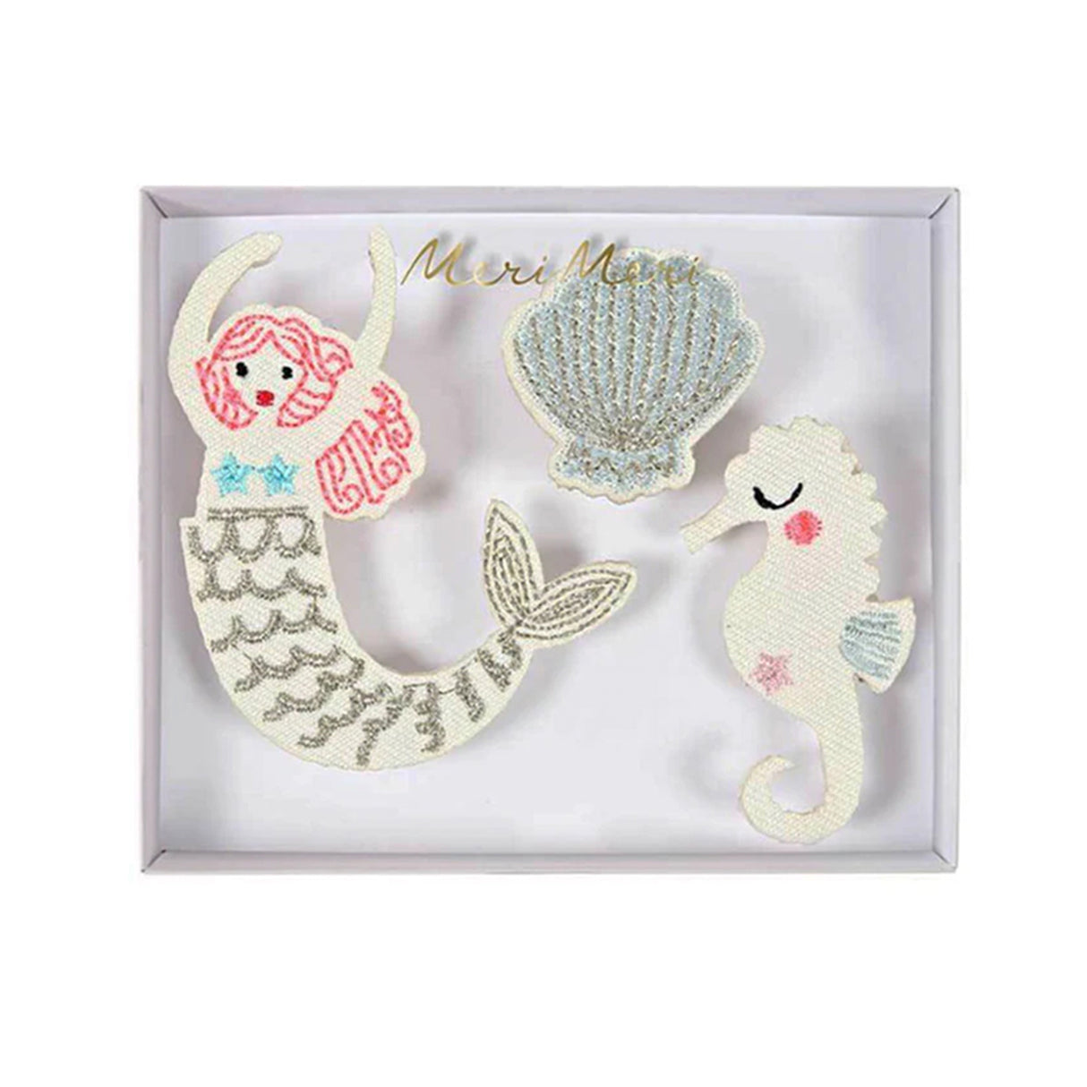 Set of embroidered brooches including a mermaid, seashell, and seahorse in a white box.