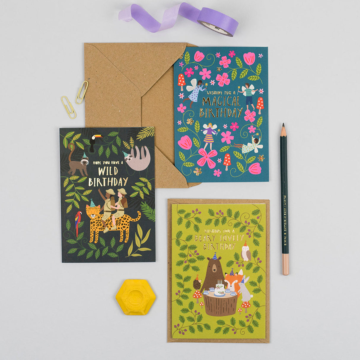 Three colourful birthday cards with envelopes on a light gray background