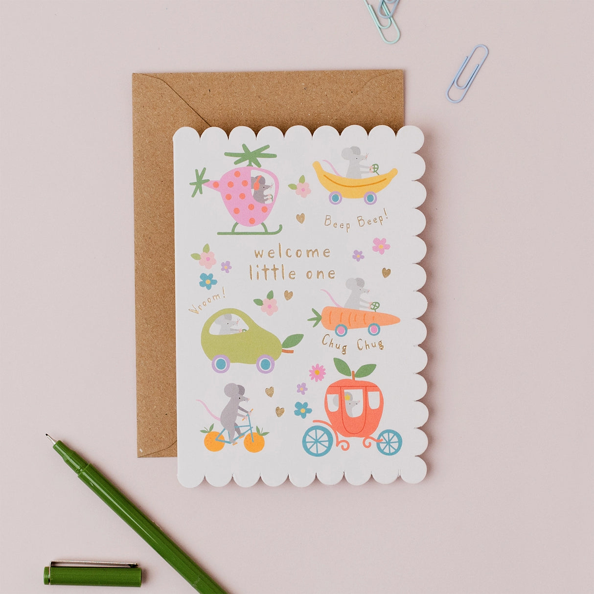 Greeting card with baby illustrations and envelope on a light pink background
