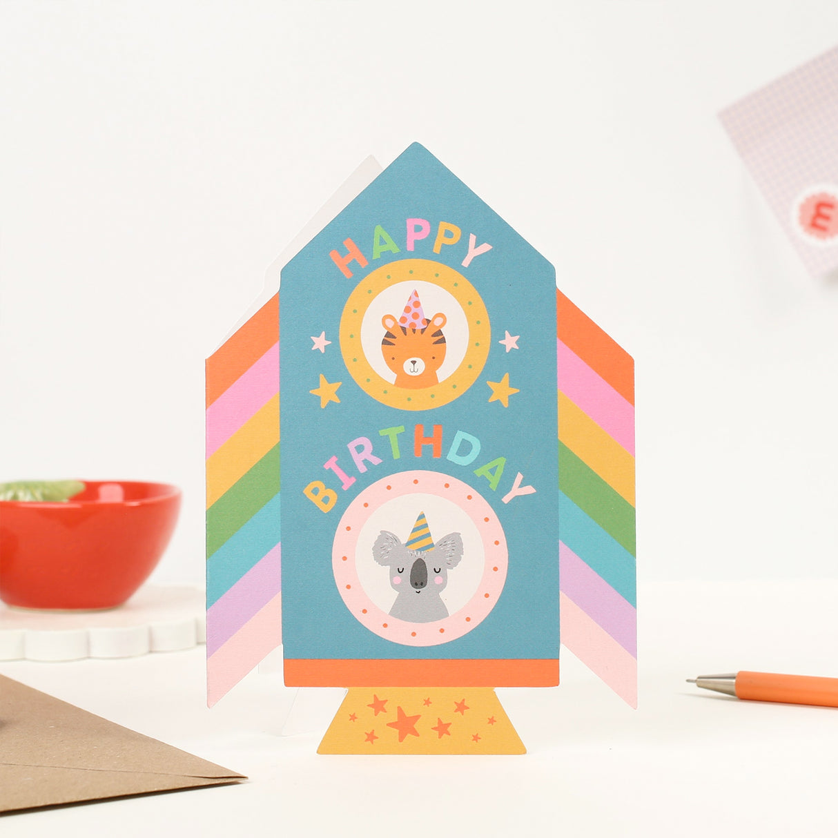 Colorful Rocket birthday card with animal illustrations on a white surface