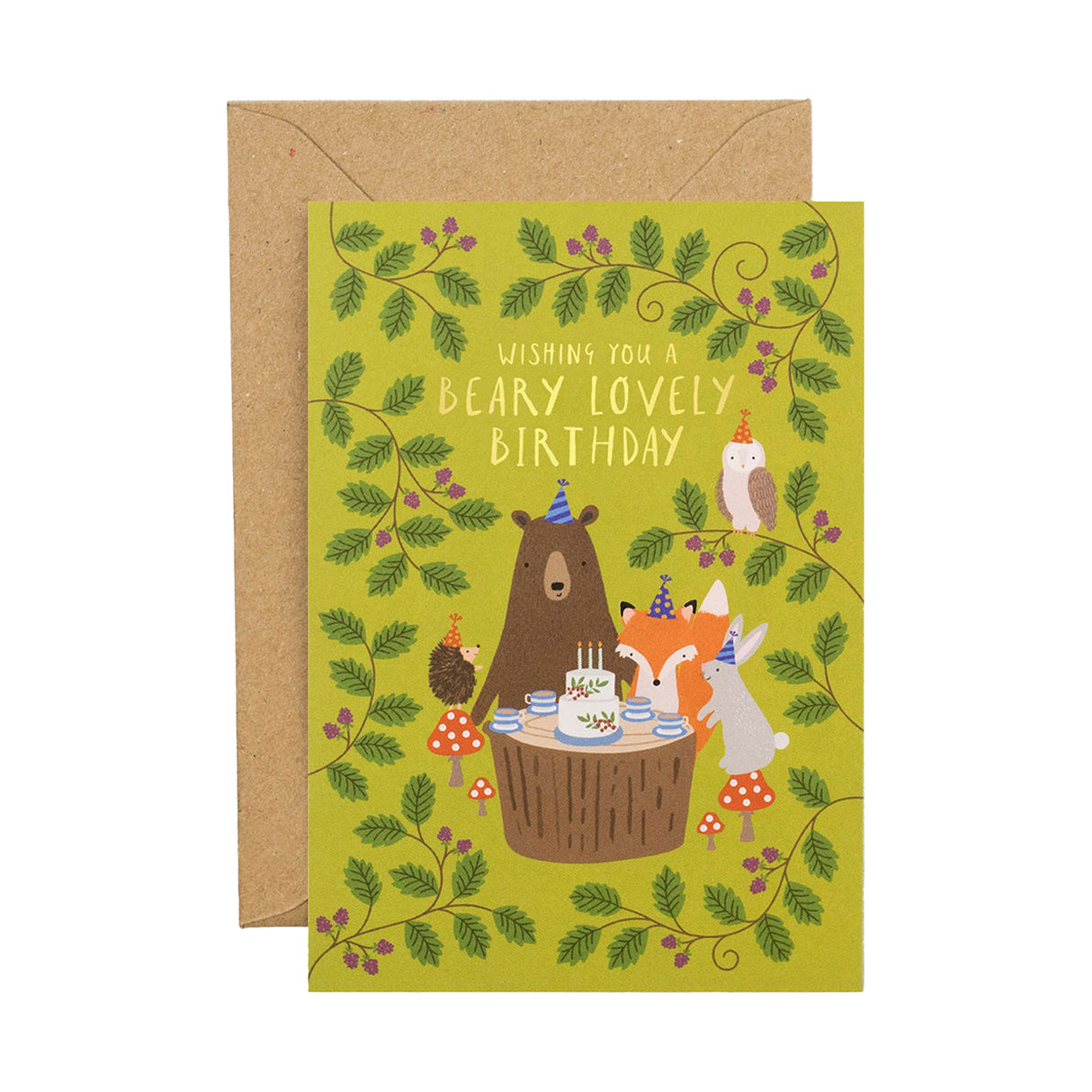 A green Birthday card with illustrated bear, fox, hedgehog, owl and rabbit around a cake on a tree stump, with leaves surrounding them. Comes with a brown envelope.