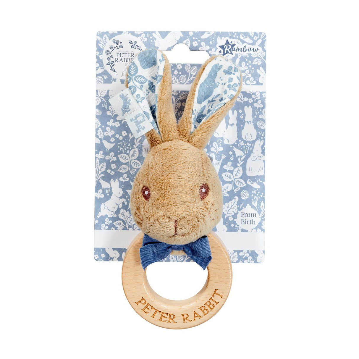 Plush Peter Rabbit toy with wooden ring and bow tie on a floral-patterned card.
