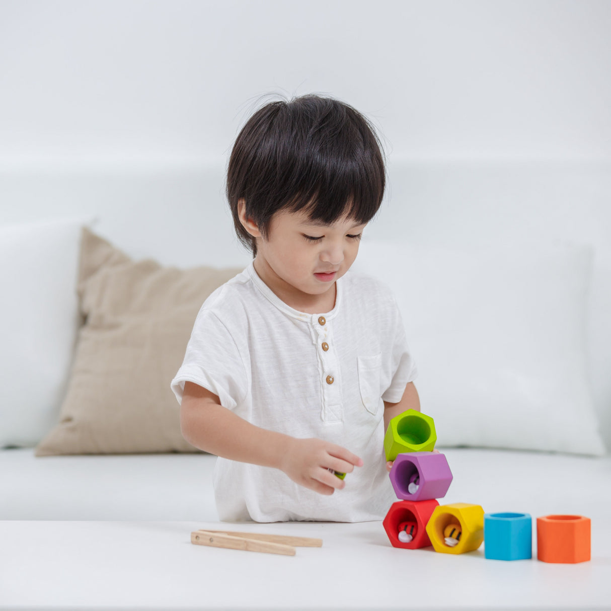 Child playing with colourful building beehive blocks