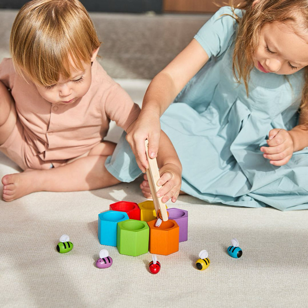 Two children playing with colourful beehive toy blocks