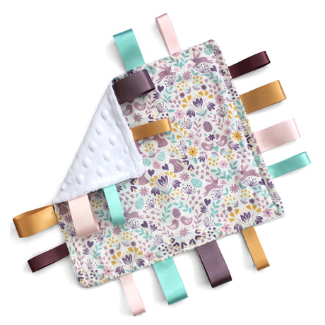 Fabric Baby taggy blanket with colourful ribbons on a white background