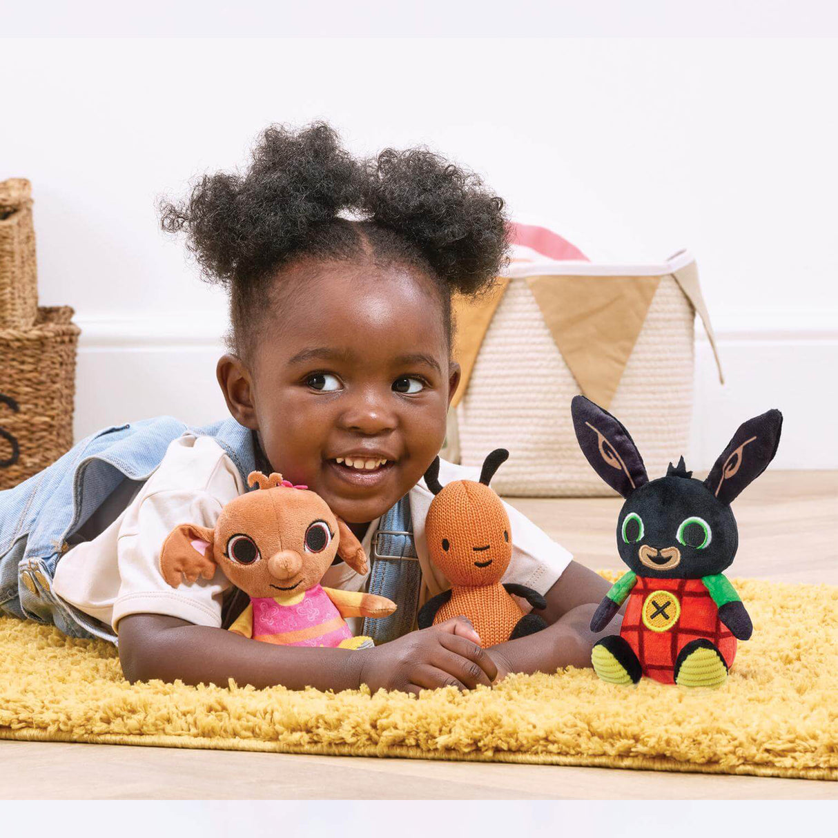 Child playing with plush Bing toys on a yellow rug