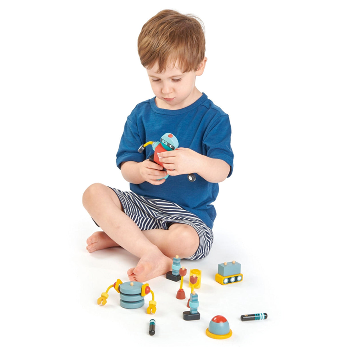 Child playing with colorful toy building blocks robot on a white background