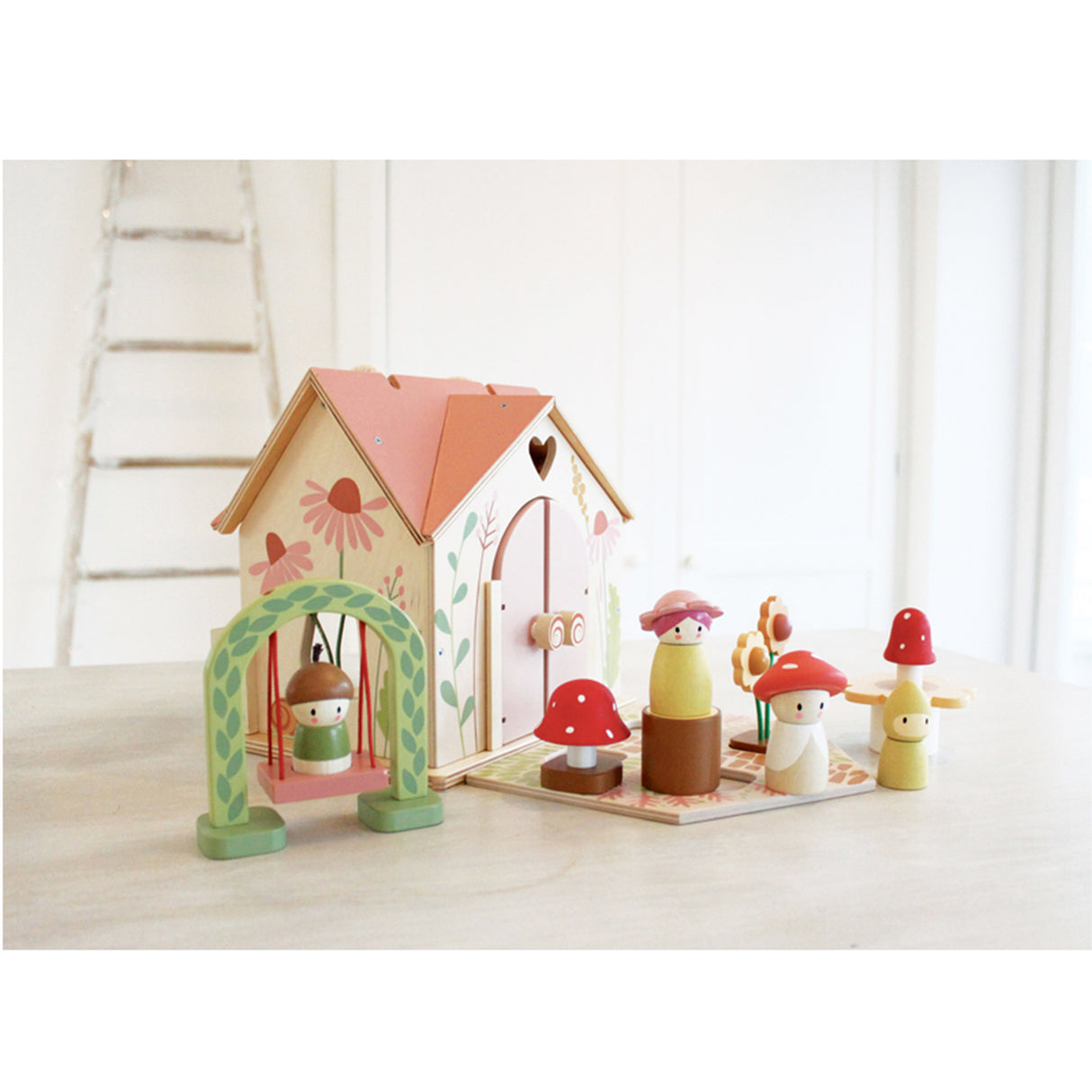 Wooden toy house with colorful characters on a light surface